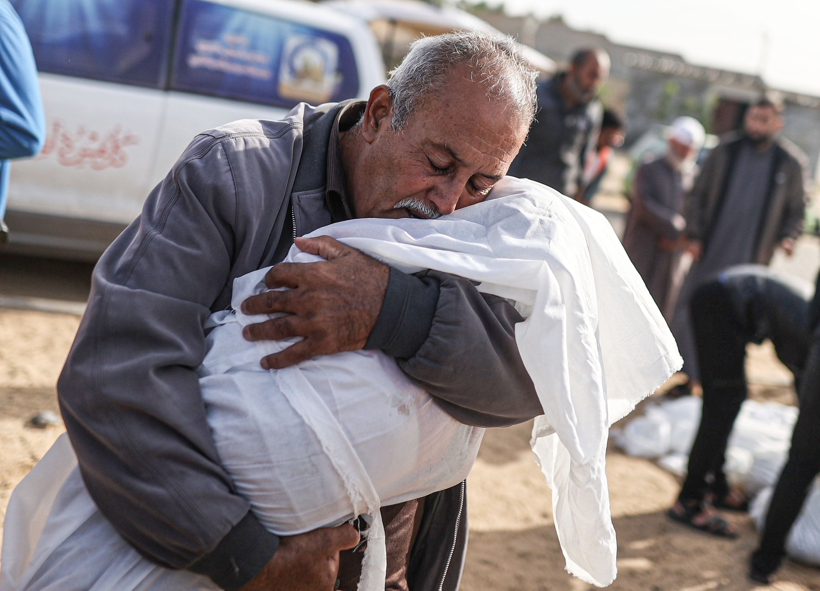 A man hugs the lifeless body of a child as Palestinians killed in Israeli attacks are taken out of the mortuary of Al-Aqsa Martyr's Hospital for burial in Deir al Balah, Gaza on November 22, 2023. 