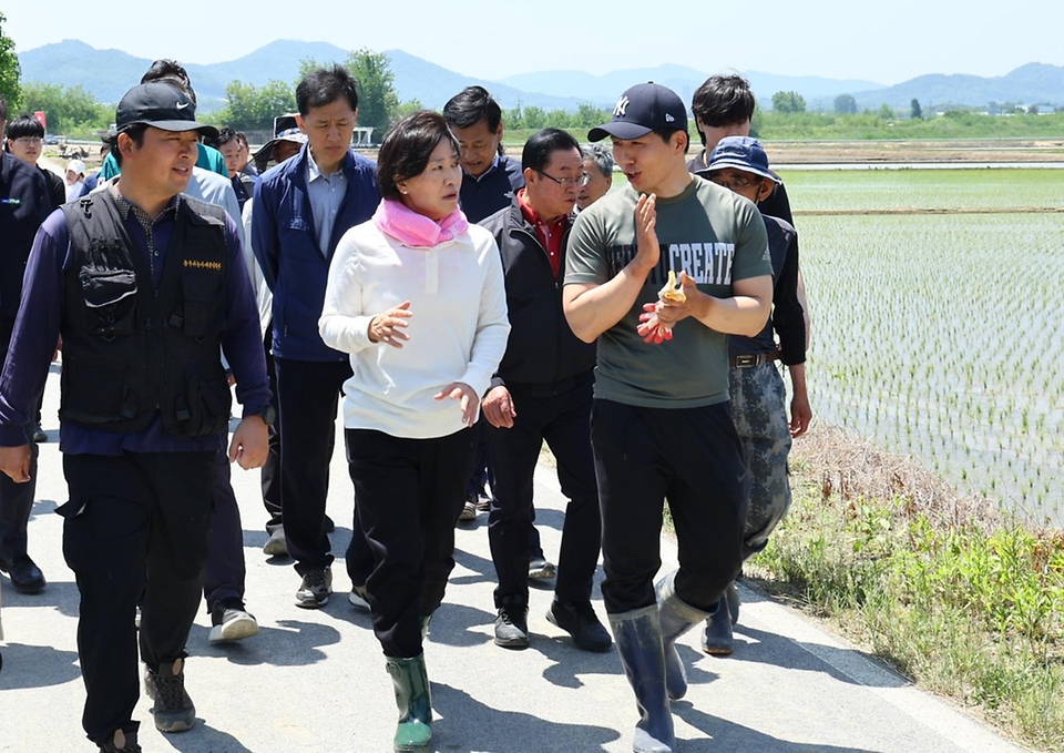 송미령 농림축산식품부 장관이 23일 충북 충주시 주덕읍 모내기 현장을 방문해 마을 주민 등 관계자들과 이동하고 있다.