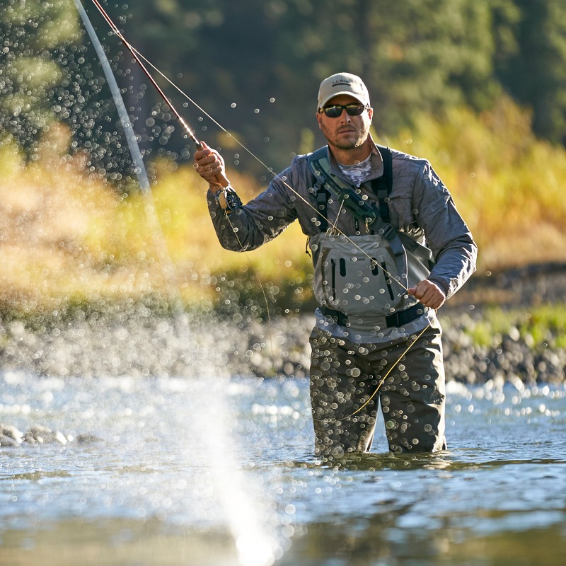 Man reeling in fishing line with water splashing in foreground