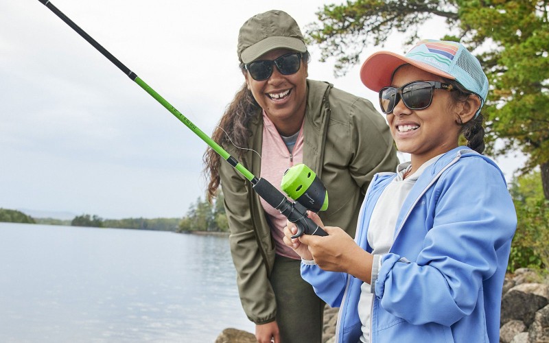 A woman and child fishing with smiles on their face