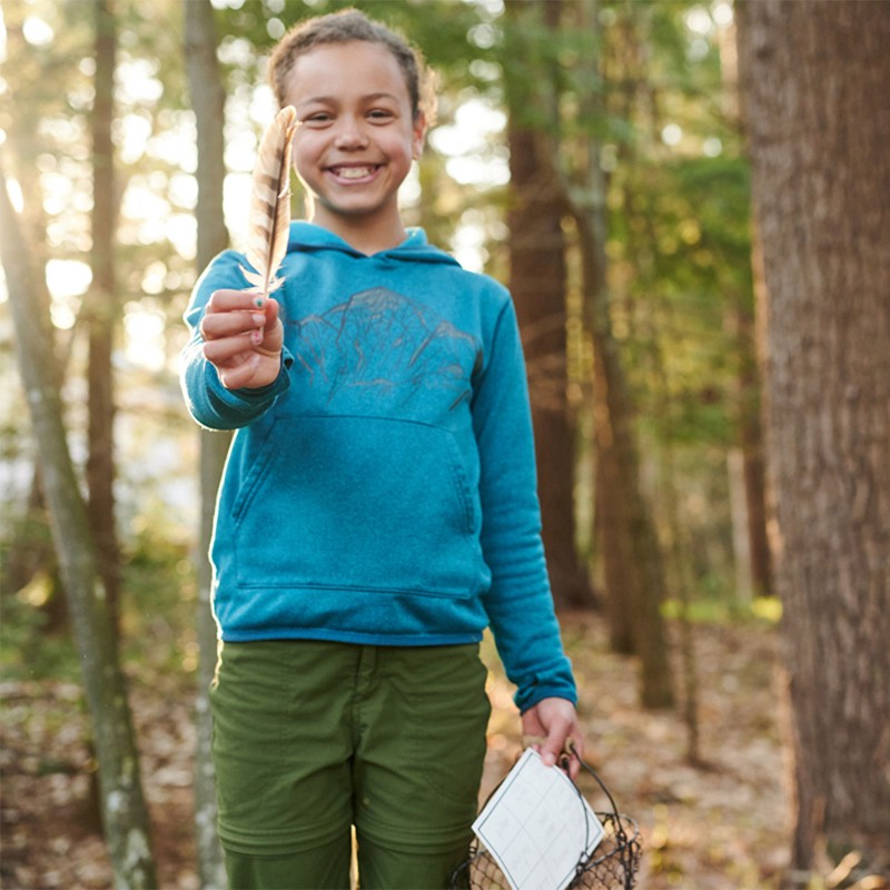 A young girl holding a feather.