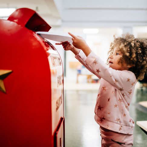 A little girl mailing a letter to Santa.