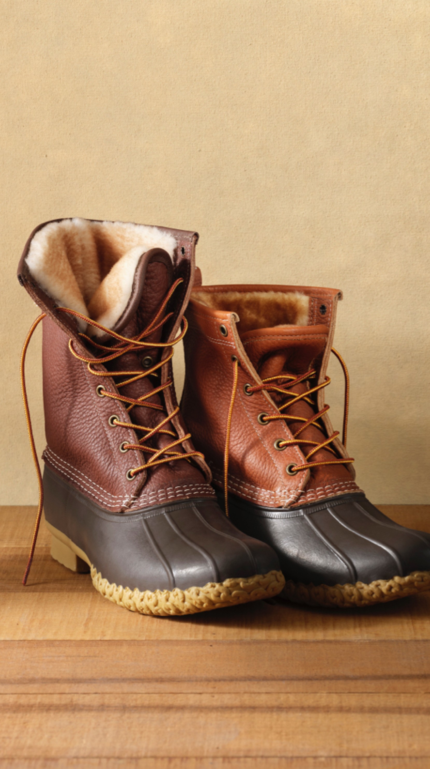 2 Bean Boots, one taller and brown and one tan, both shearling-lined.