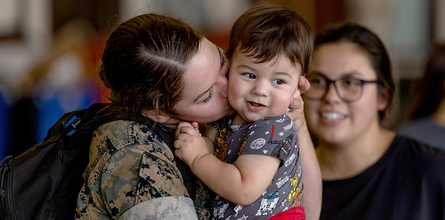 service member kissing child