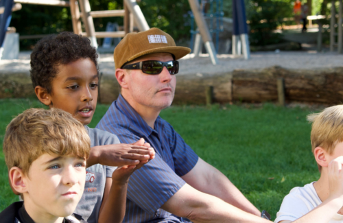 PYP Curriculum Coordinator Armin Martin sits with students during a lesson