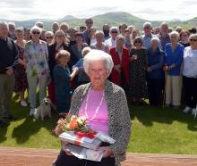 Doris Inglis holds gifts and flowers that were given to her by friends and family for her 100th...