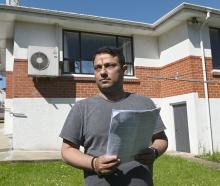 Nitish Thaman, of Dunedin, with a sheaf of the household bills eating his family's home deposit...