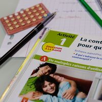 Une page de manuel scolaire de quatrième portant sur la contraception, avec en arrière-plan un échantillon de pilules contraceptives, 15 juin 2016.