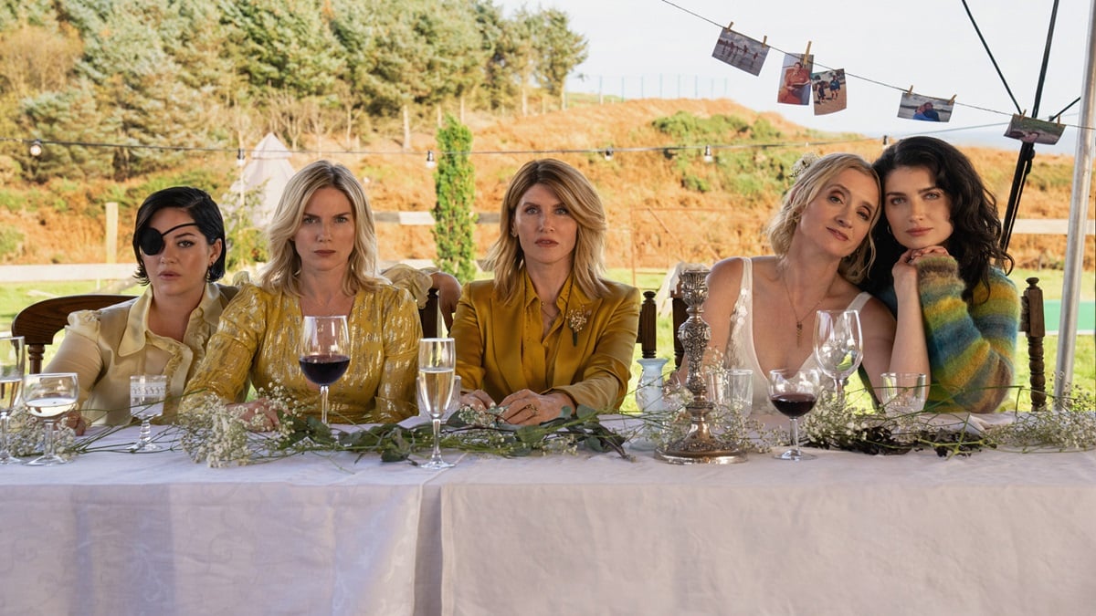 Five sisters sit at a table looking miserable in 'Bad Sisters'