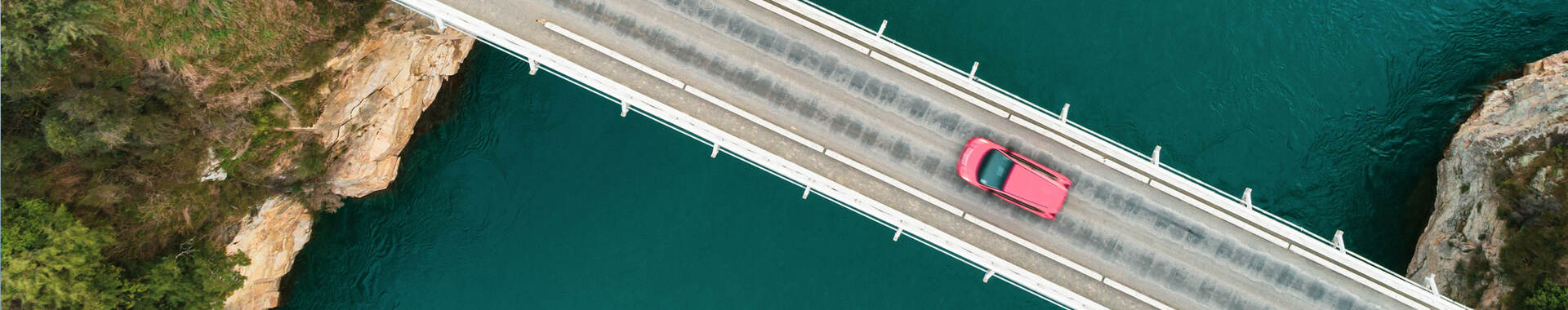 Overhead view of a car going across a bridge