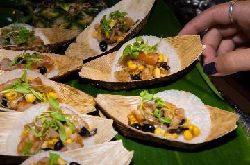 hand selecting a paper boat with taco inside