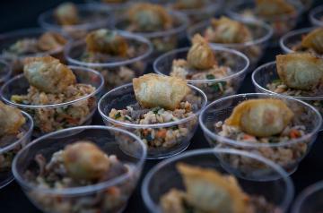 Cups of fried rice topped with deep fried wonton laid out on a table