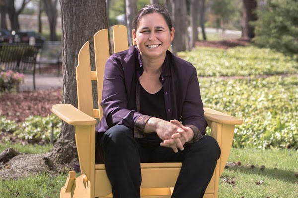 Maya Gupta, a machine learning Research Scientist at Google, sits in a lawn chair at a park. She wears a purple shirt with black pants.
